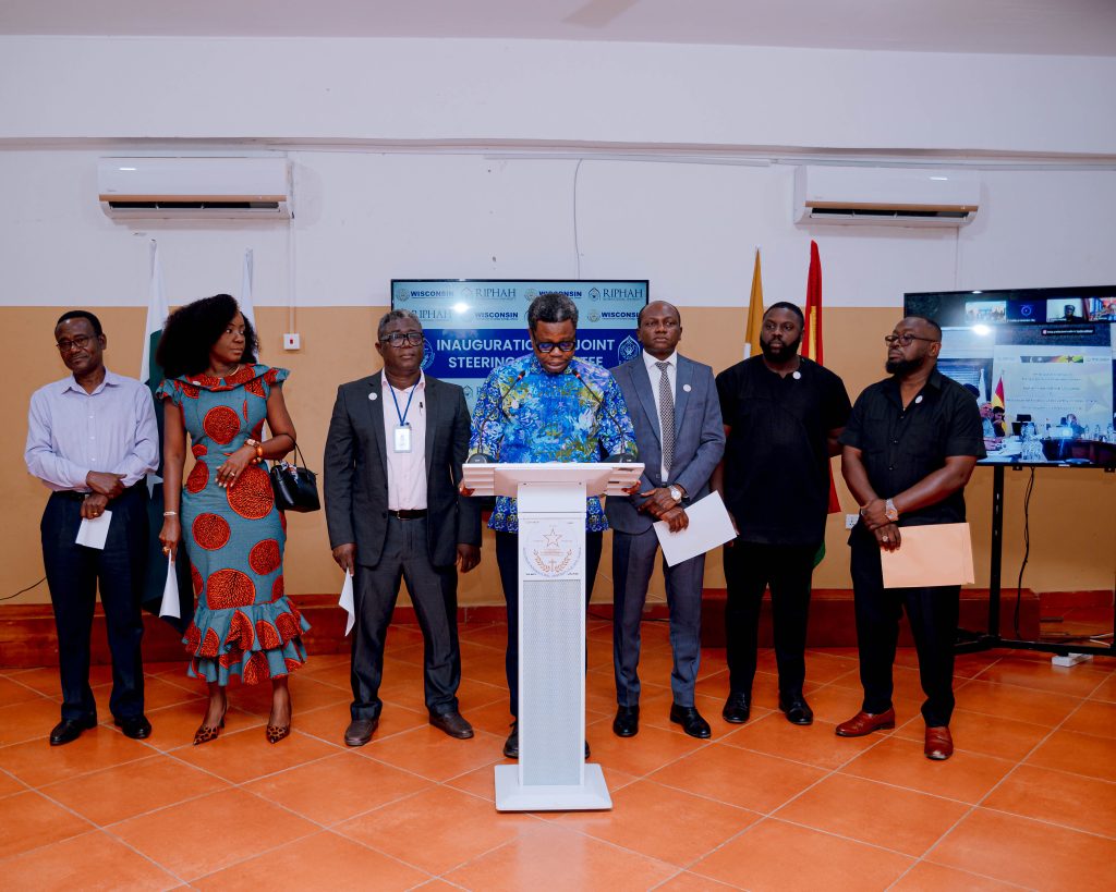 WIUC Ghana members of the Joint Steering Committee standing together as an official addresses the inauguration ceremony.